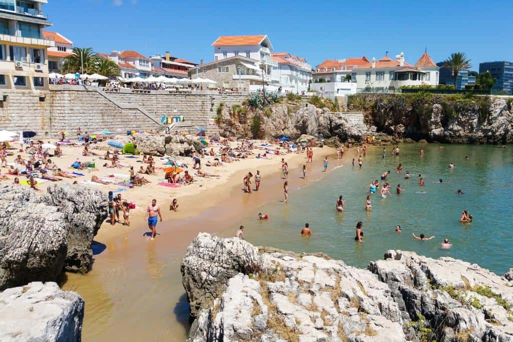 Busy beach next to a cobblestone town in Portugal