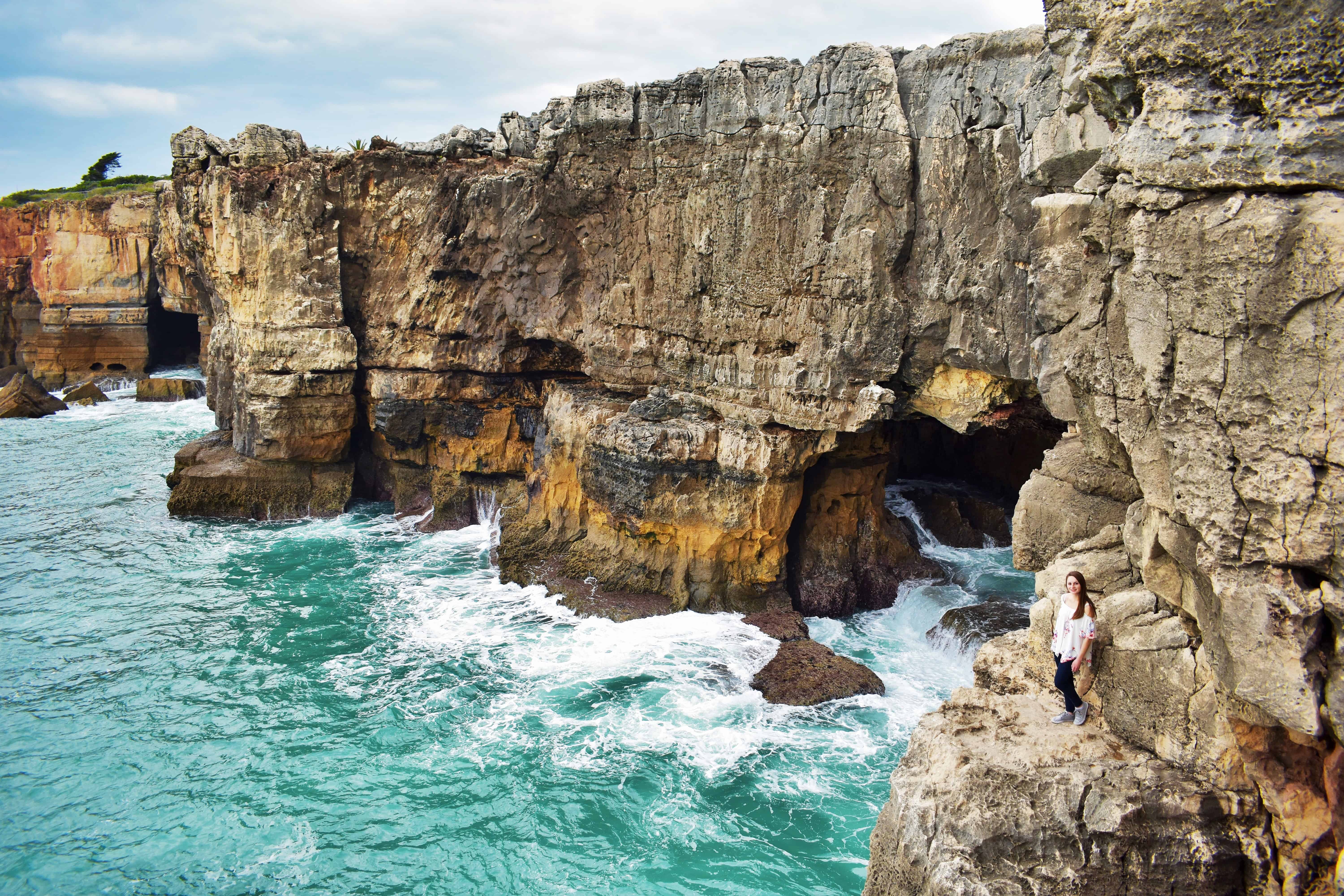 Girl standing on the cliffs at the Boca do Inferno in Portugal