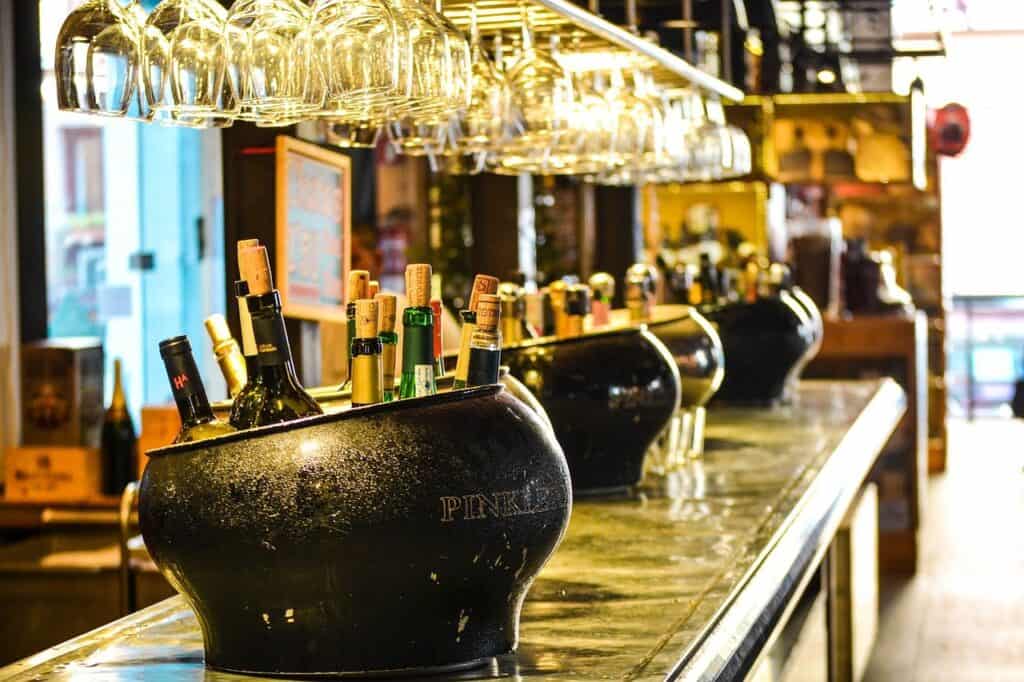 Large buckets of alcohol on top of an empty bar