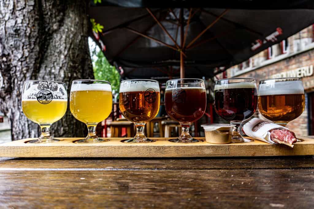 Flight of small beers on a wooden tray in a pub
