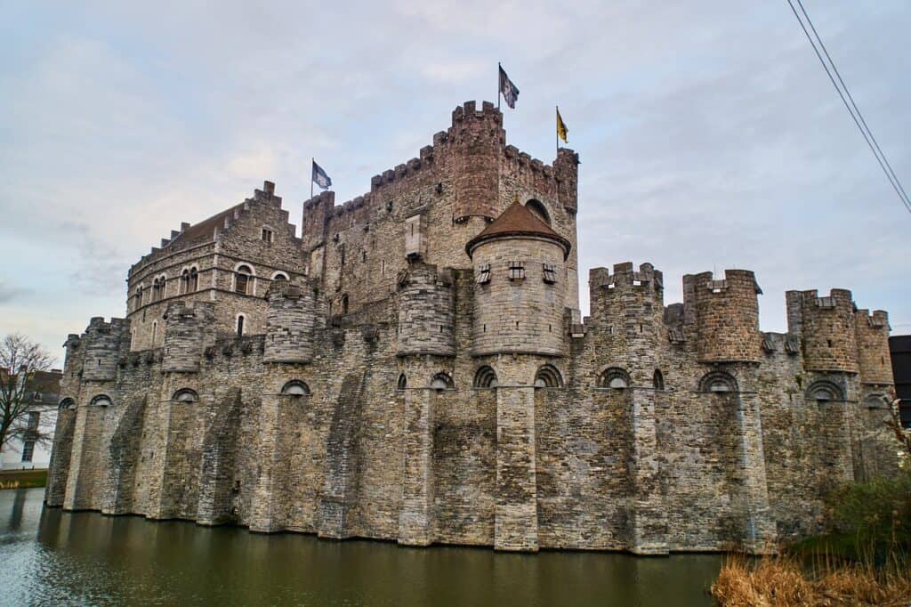 Large castle with a moat in Belgium on a cloudy day