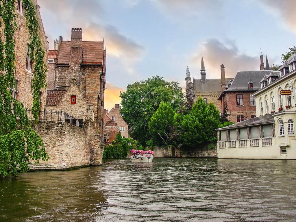 Water level in Bruges canals with a boat tour of people