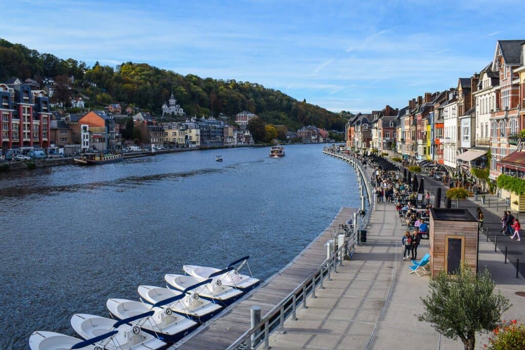Dinant's sidewalk lined with shops and restaurants along the river