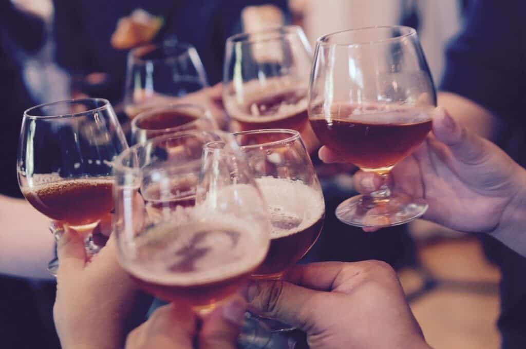 People clinking half-full beer pints together