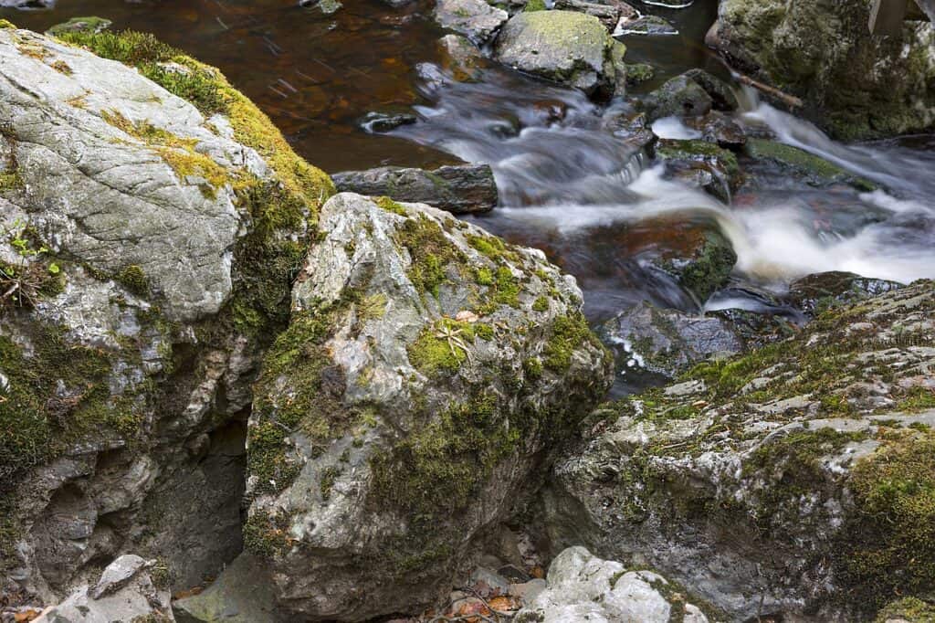 Fast-flowing waterfall surrounded by mossy rocks