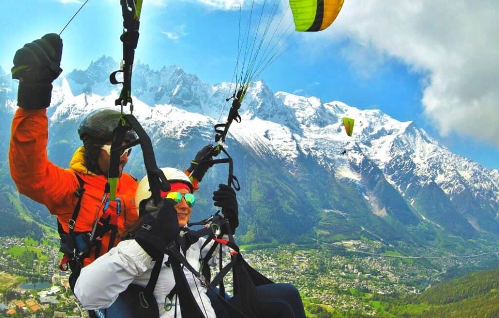 Emily and an instructor paragliding near Mont Blanc in the French Alps over the town of Chamonix