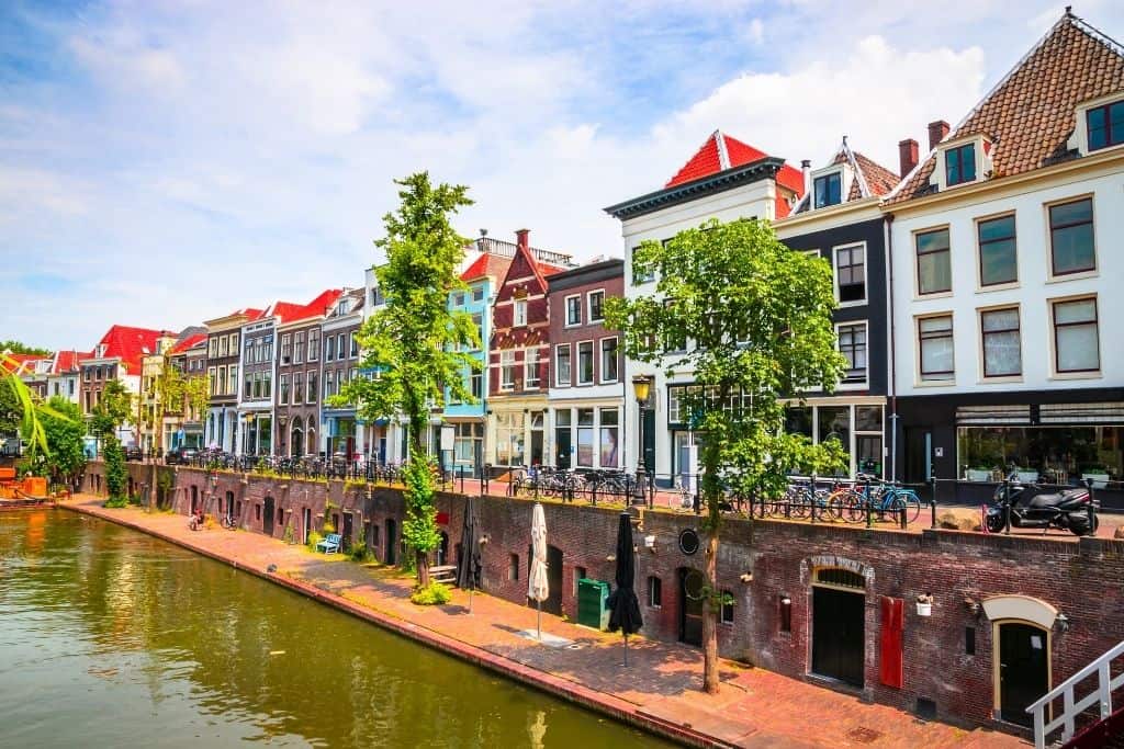 A beautiful photo of Utrecht's waterfront lined with colorful houses and trees