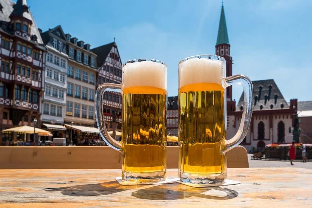 2 tall pints of beer on an outdoor table in a German city