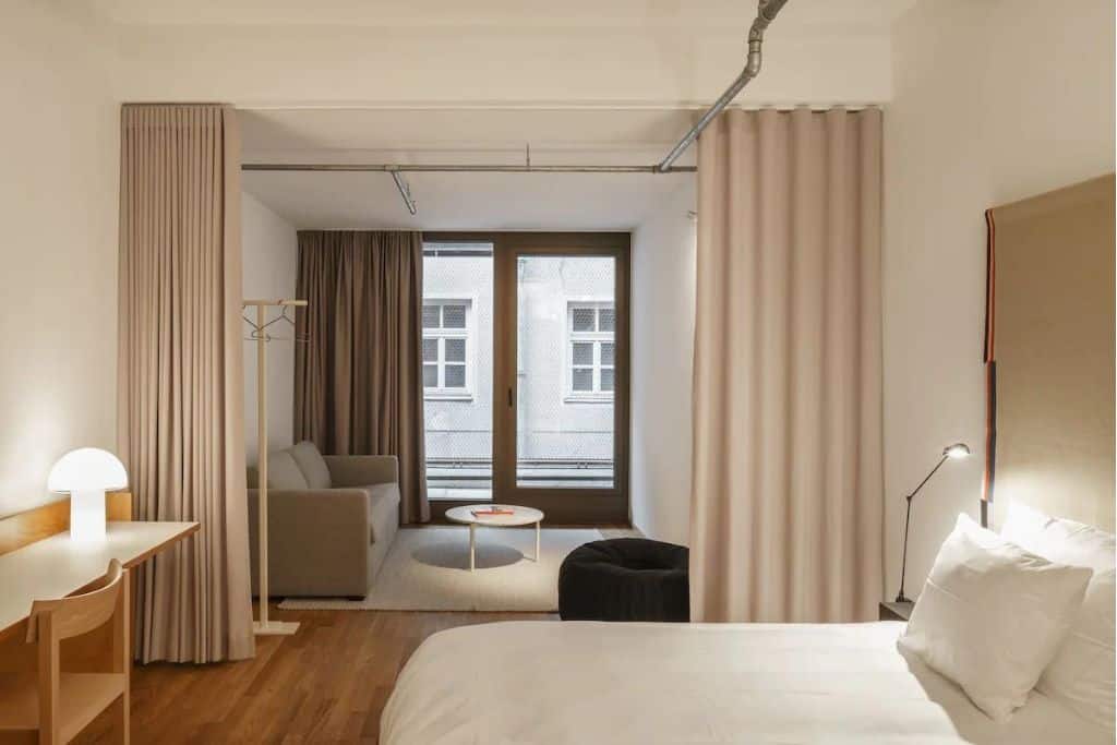Modern, white hotel room with windows and curtains