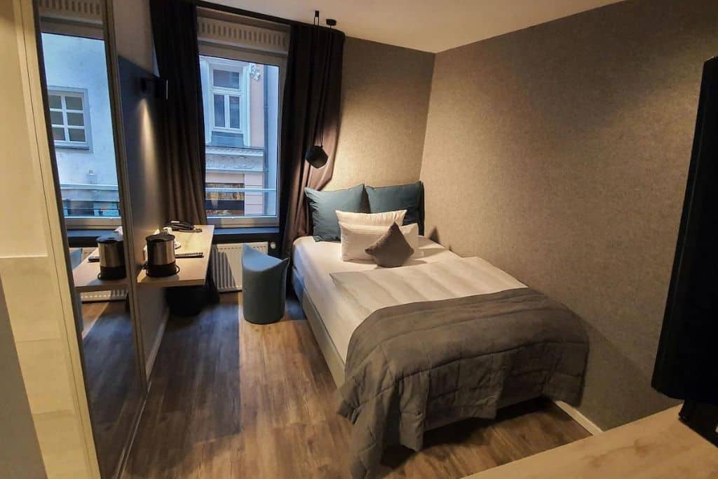 Basic hotel room with a twin bed and single window