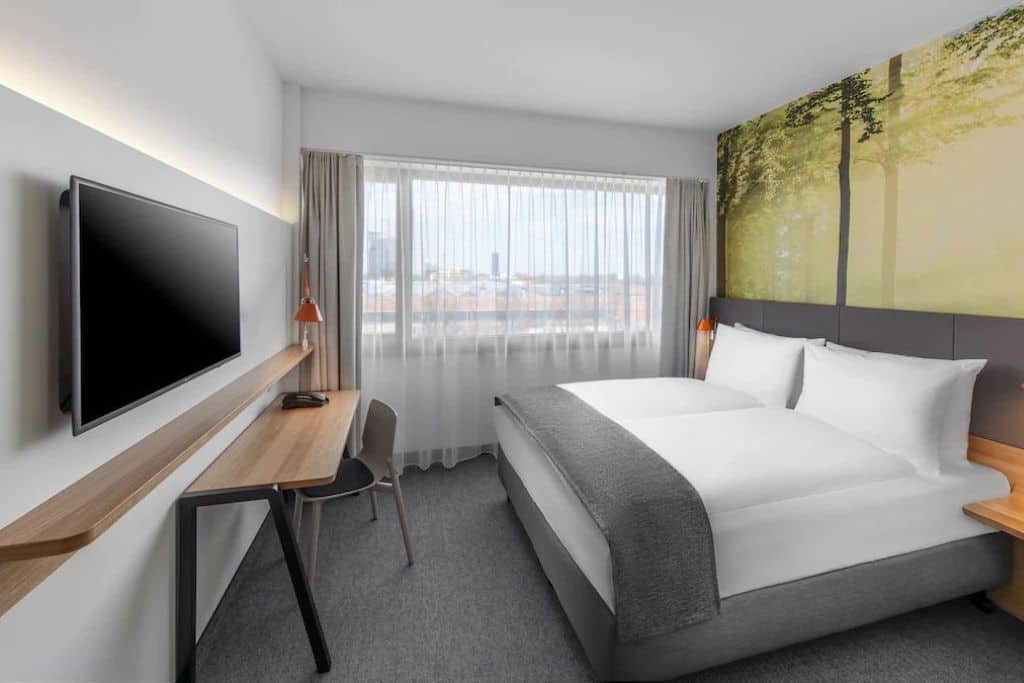 Modern hotel room with a TV and work desk
