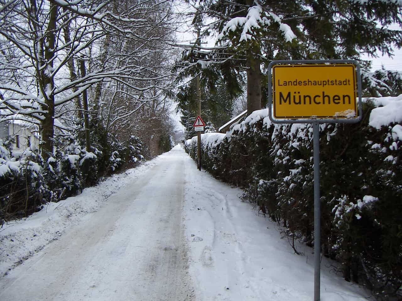 Snowy road in Germany with a yellow sign written in German