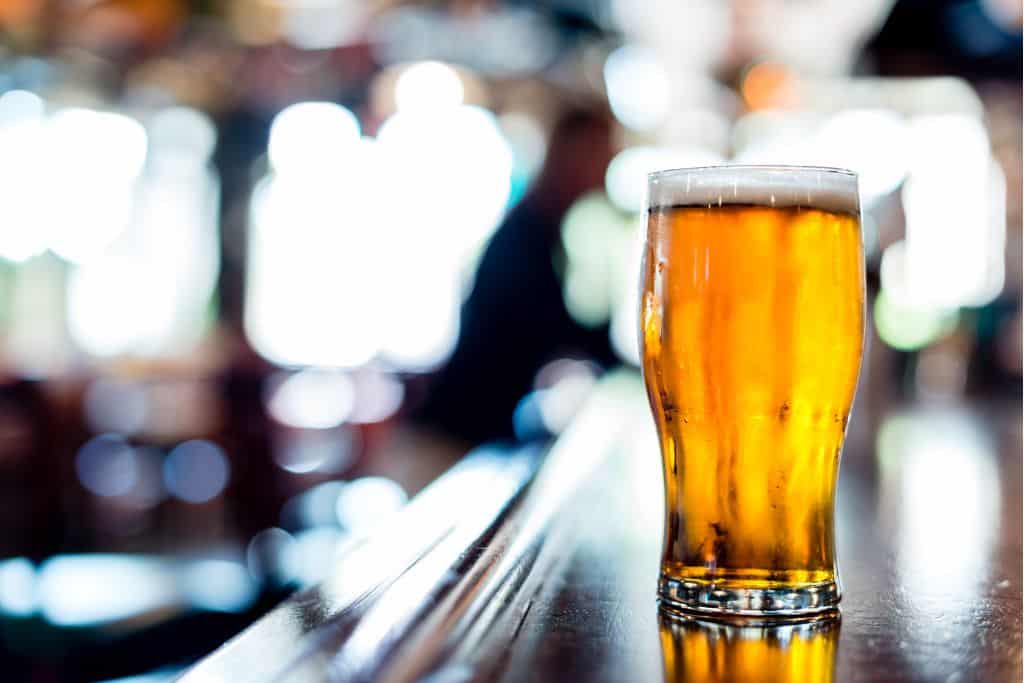 Full pint glass on a wooden bar