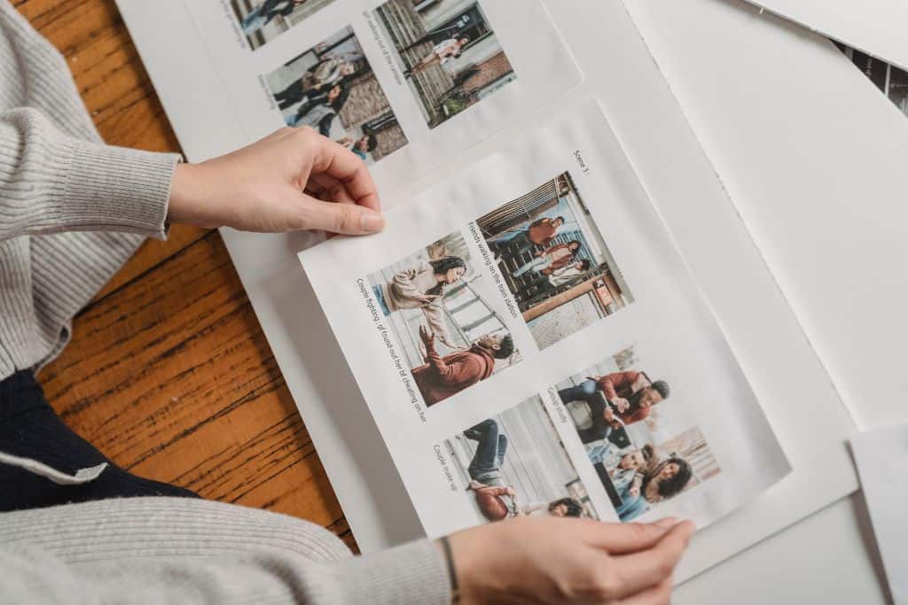 White photo album with someone putting pictures in