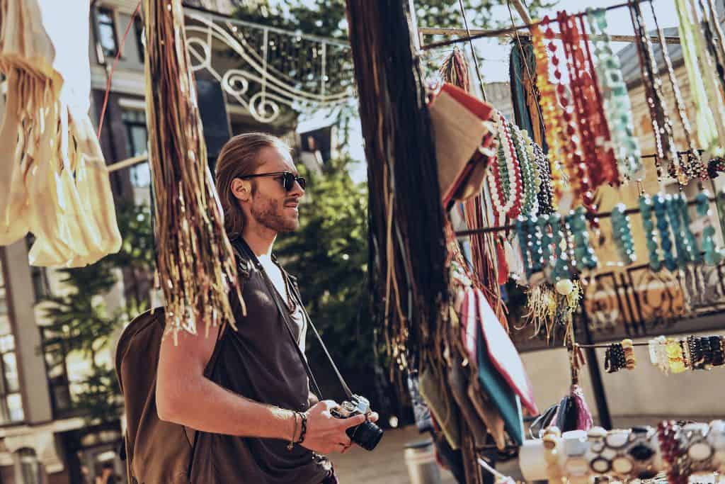 Man shopping in an outdoor market with a camera