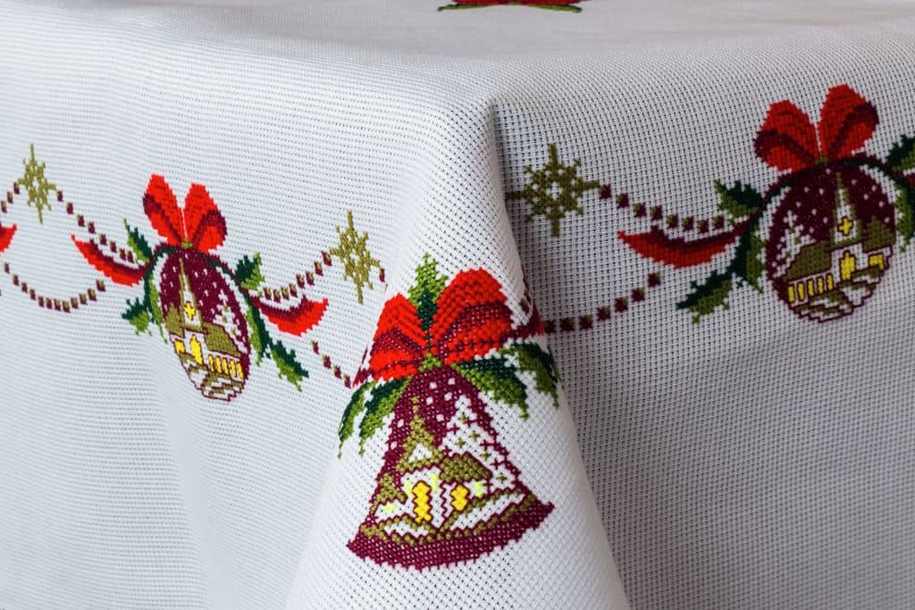 White tablecloth with bells and red ribbons stitched in