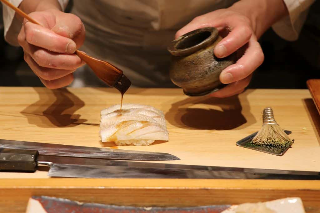 Person putting together a fancy sushi plate