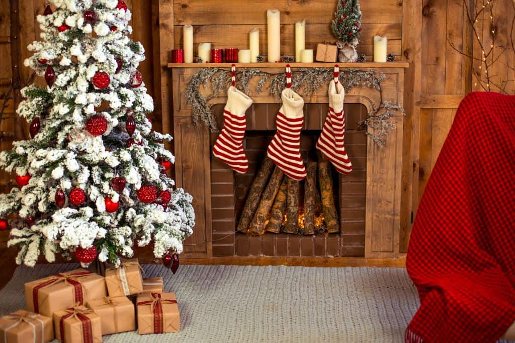 Christmas tree and stockings hanging over a fireplace in a living room