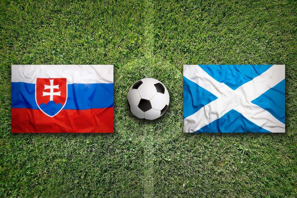 Two flags next to a soccer ball on a soccer field