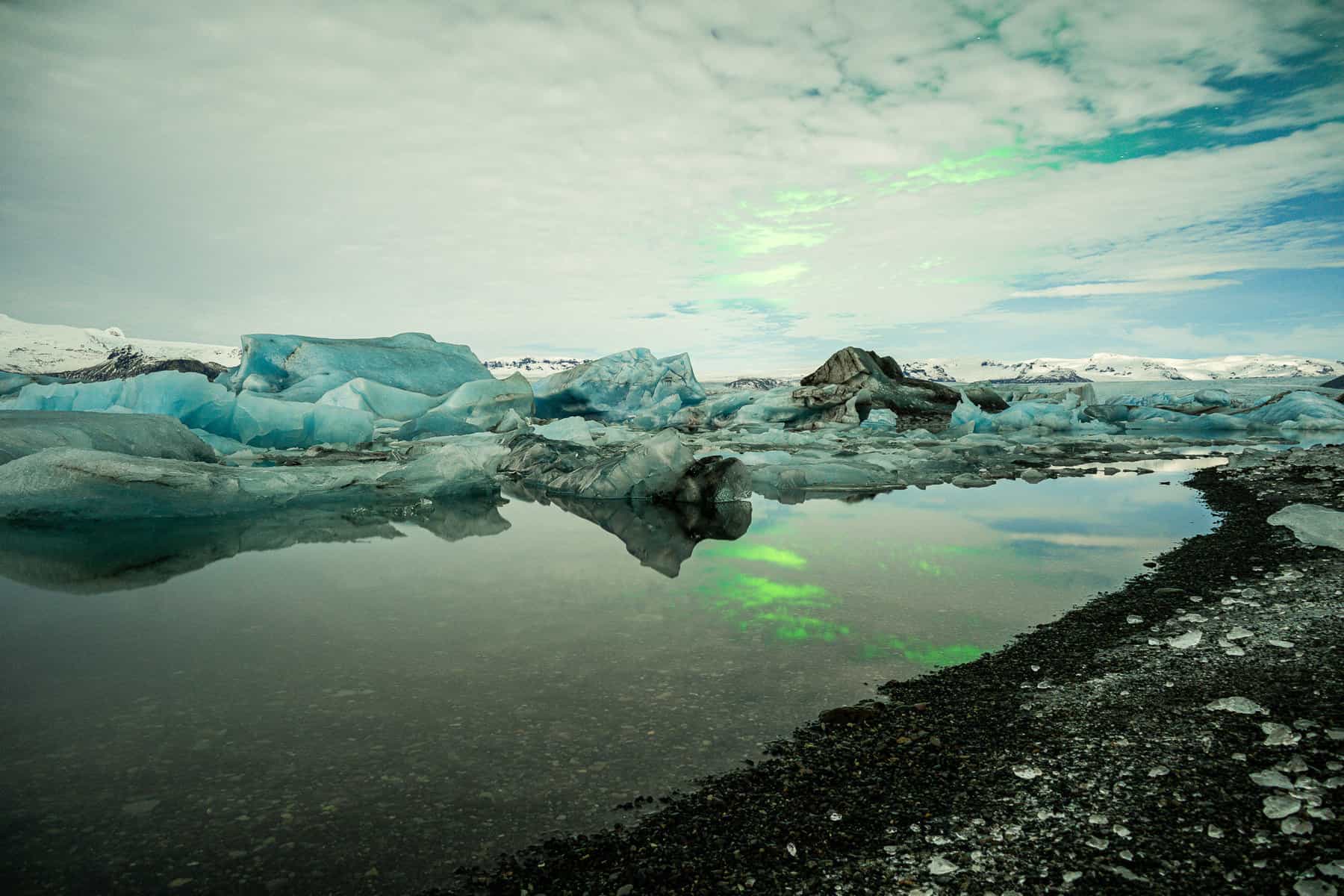 Northern lights on a cloudy night over the glacial lagoon in Iceland