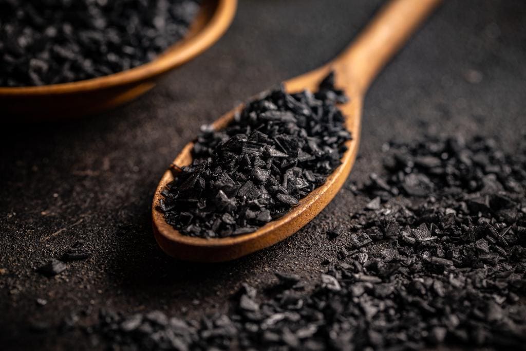 Black lava salt in a wooden spoon