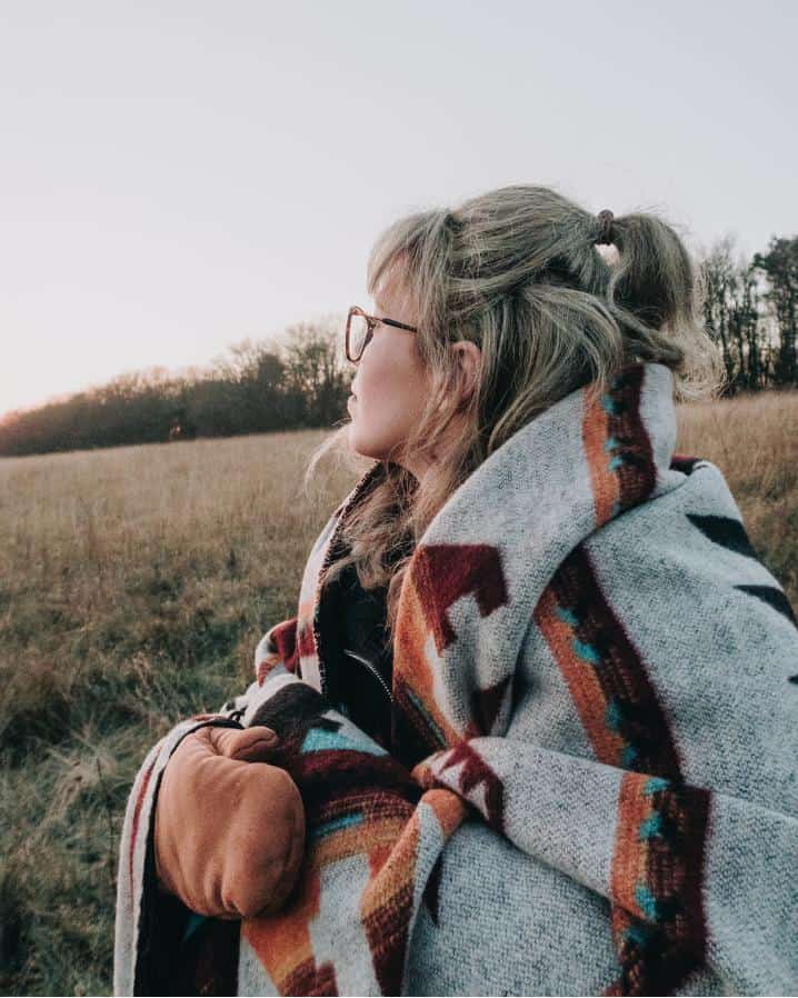 Woman in a field with an Icelandic wool shawl on