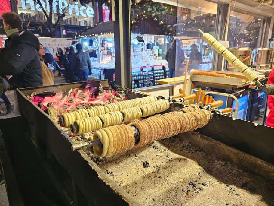 Traditional Czech trdelník being rotated and cooked over coals