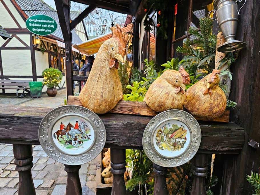Wooden roosters and metal plates decorating a wooden cabin
