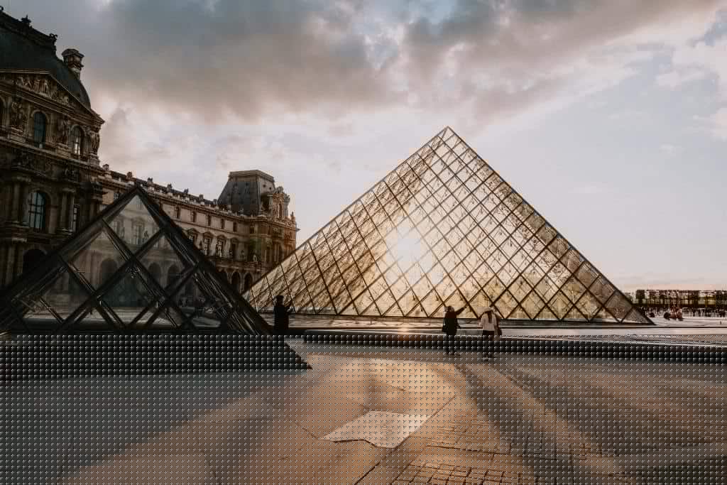 Le Louvre museum in Paris lit up at sunset