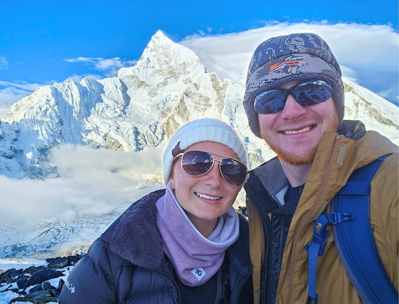 Sean and Emily Concannon of Concannon Adventure Travel taking a selfie with Mount Everest and Mount Lhotse in Nepal behind them