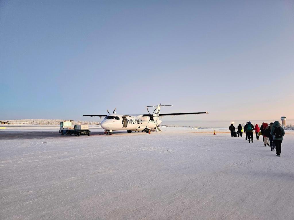 Finnair flight on a snowy runway with passengers walking out to it