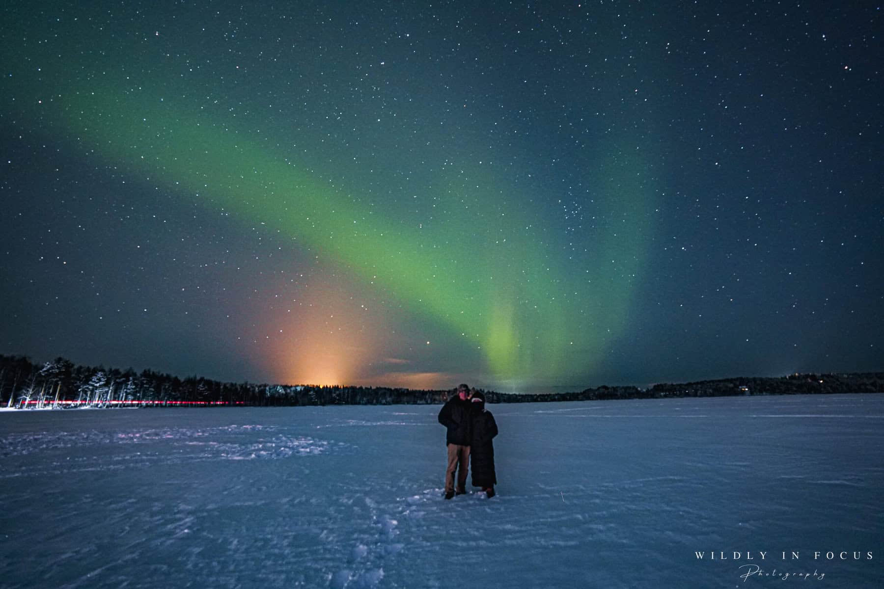 Emily and Sean Concannon under the northern lights on a frozen lake outside of Rovaniemi, Finland