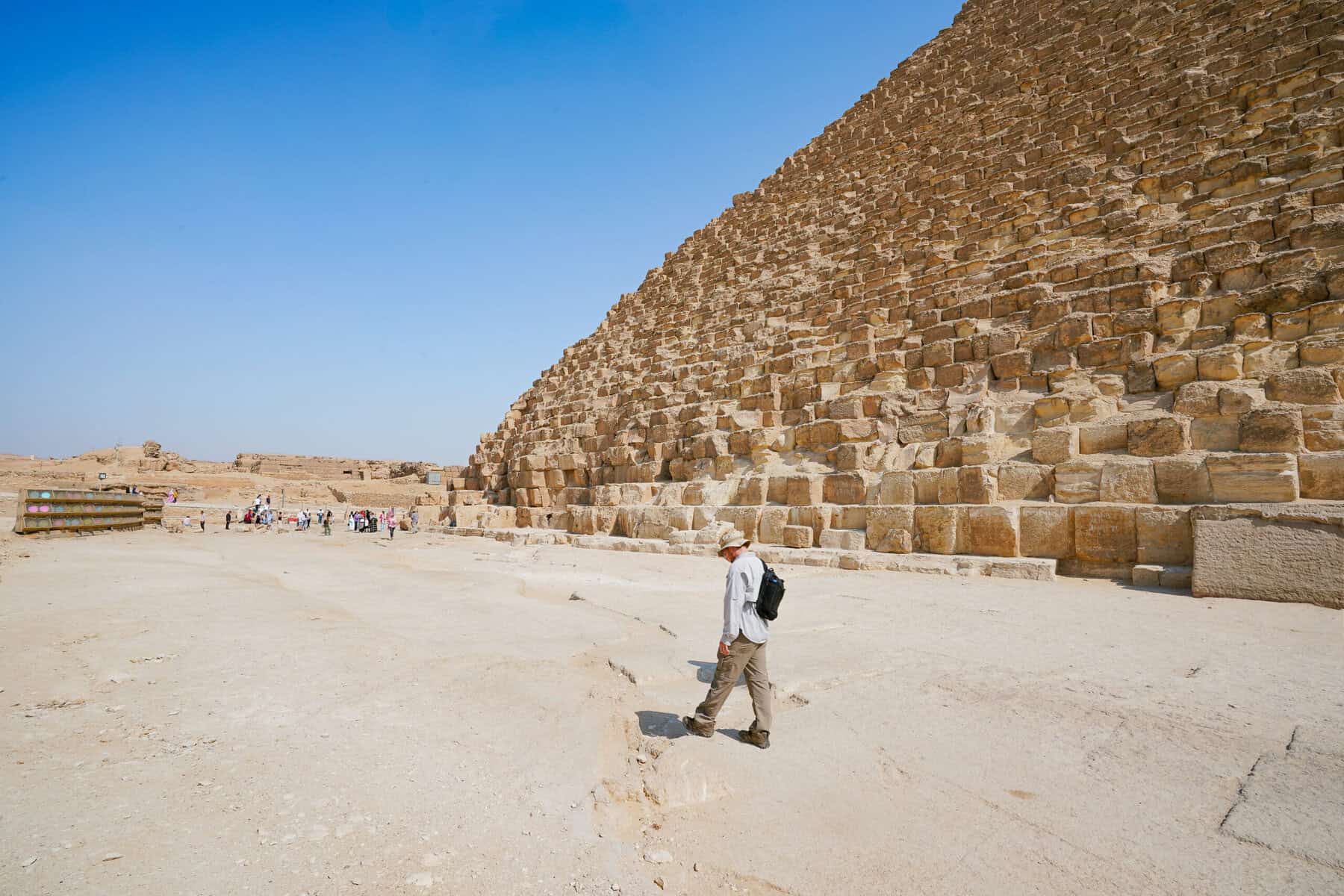 Sean Concannon wearing a black backpack walking next to the pyramids of Giza